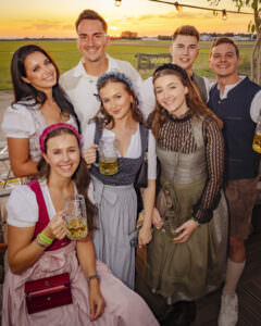 Gäste posieren gemeinsam im Festzelt beim RÜ Oktoberfest // Flughafen Essen/Mülheim